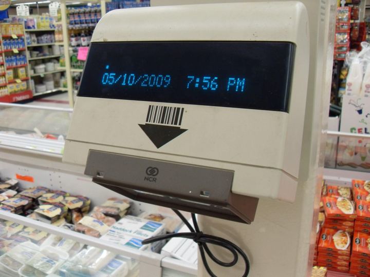 An older barcode scanner built into a supermarket checkout