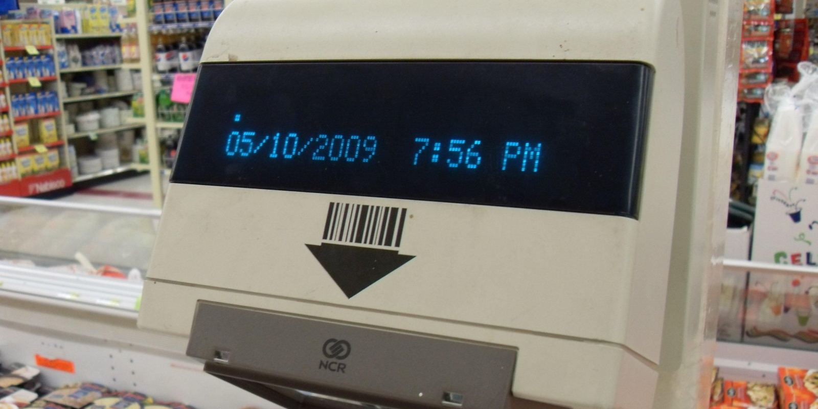 An older barcode scanner built into a supermarket checkout
