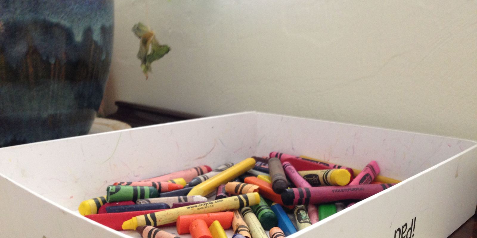 An open box of colourful wax crayons