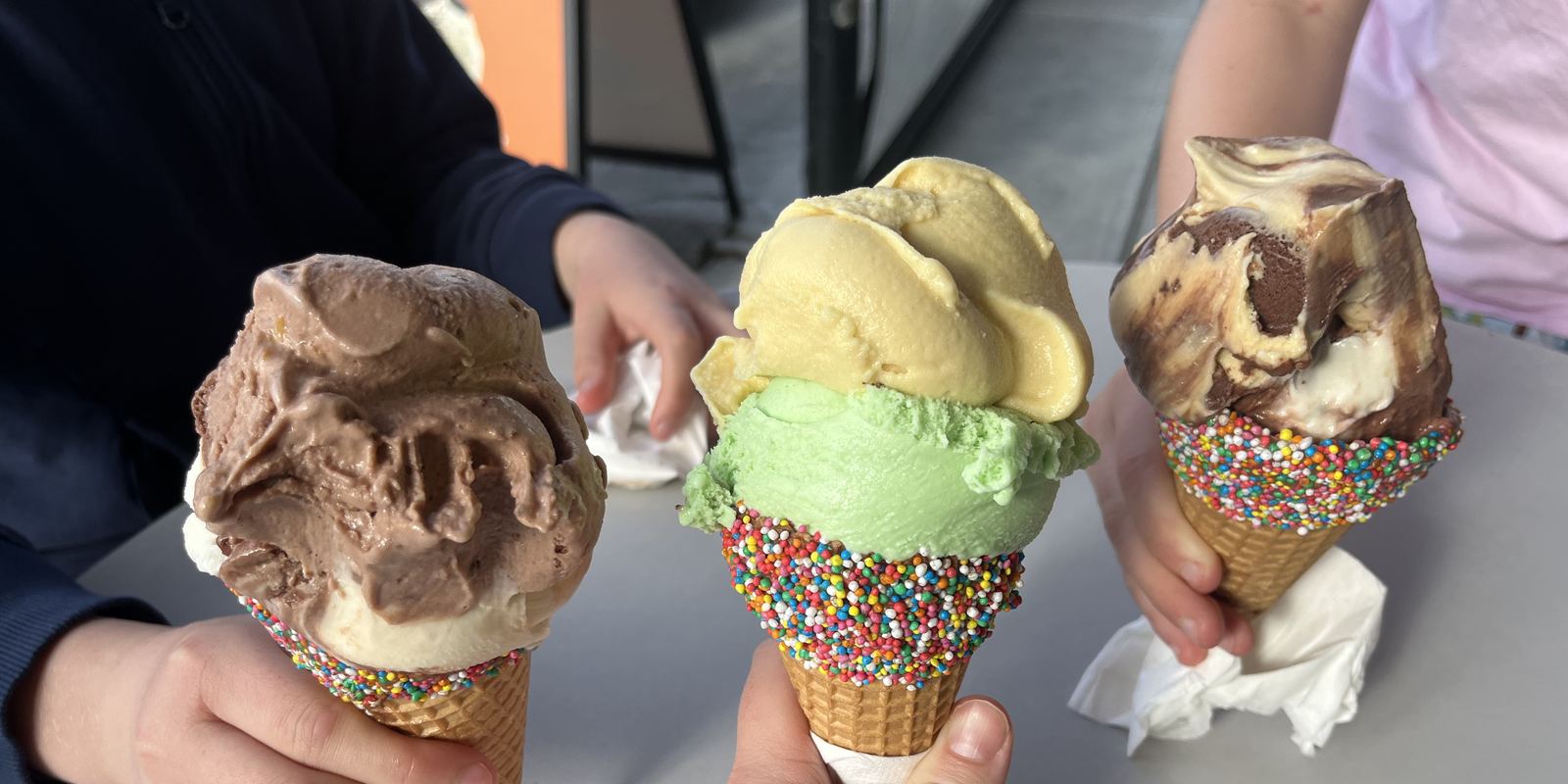 Several ice cream cones with colourful scoops