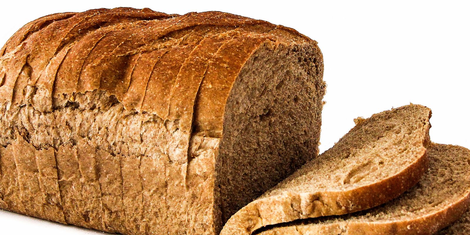 A loaf of fresh bread cut into slices on a board